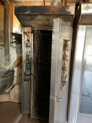 a dirty kitchen with a sink and oven in it