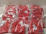 beaucoup de t-shirts rouges dans des sacs en plastique posés sur une table