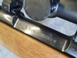 a close up of a rifle scope on a wooden table