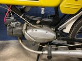 a yellow motorcycle parked next to a blue wall