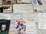 a pile of old papers on a table with a bottle of wine