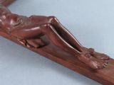 a wooden sculpture of a man laying on a cross