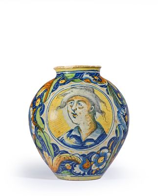 un vase bleu et jaune sur lequel est représenté un homme