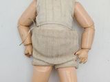 a doll that is standing on a white surface