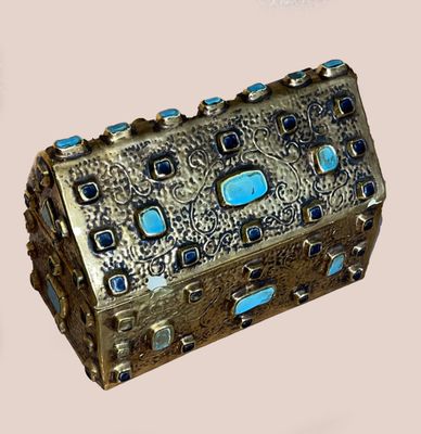 a silver box with blue stones inside of it