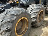 un gros tracteur garé sur un terrain en terre battue