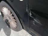 a black car that is parked on the side of the road