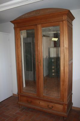 a large wooden cabinet with a mirror on top of it