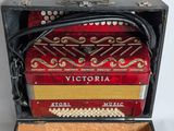 a red accordion sitting in a case on a table