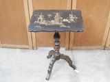 une petite table ornée d'un motif noir et or