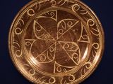 an image of a gold plate with designs on it
