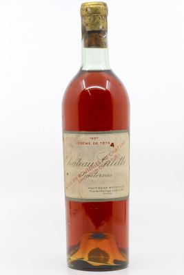 une vieille bouteille de vin posée sur une surface blanche