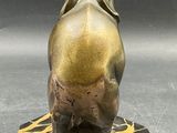 statue of an elephant on a marble base with a sword in its trunk