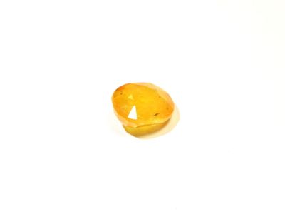 un gros plan d'une pierre jaune sur une surface blanche