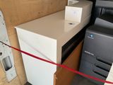 a white refrigerator and a black and white printer in a room