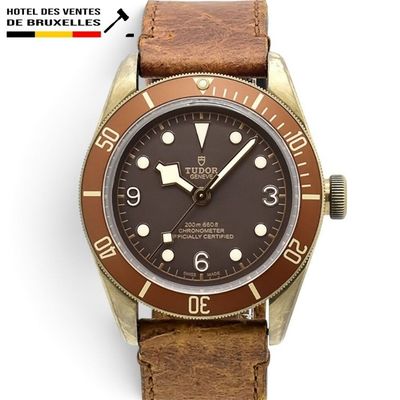 une photo d'une montre-bracelet marron et dorée, montée sur un bracelet en cuir marron