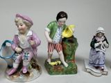 several figurines of children are sitting on a bench