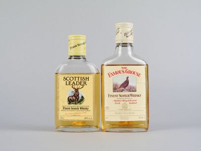 deux bouteilles de whisky posées l'une à côté de l'autre sur une table