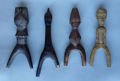 quatre figurines en bois sont alignées sur une surface blanche
