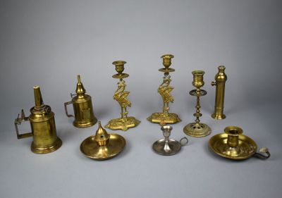 a group of brass candlesticks and other items on a table
