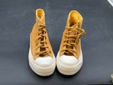 yellow sneakers with white soles are on a black surface