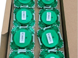 a cardboard box filled with lots of green discs