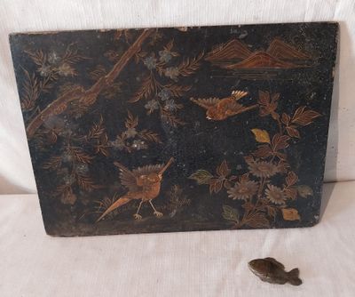 une boîte noire ornée d'un oiseau, posée sur un fond blanc