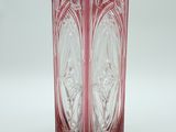 une photo d'un vase en verre rouge posé sur une table blanche