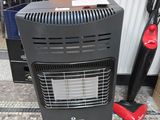 un radiateur noir posé par terre à côté d'un aspirateur rouge