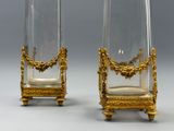 paire de vases en verre plaqués or, posés sur des socles, sur un support gris