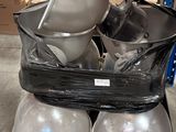 une pile de bols et de casseroles posée sur une palette dans un entrepôt