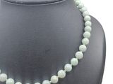 a close up of a necklace on a mannequin with a white background