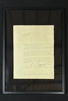 framed photograph of a signed document in a black frame on a wall