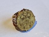 Gros plan sur une bague ornée d'une pièce d'or