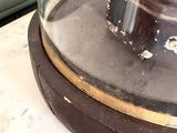 a glass dome on top of a table with a clock on it