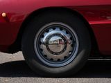 a close up of a red car parked on the side of the road