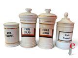 three white ceramic jars with labels on them sitting next to each other