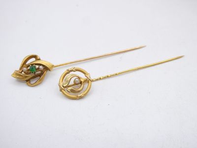 a pair of gold earrings with green stones on them