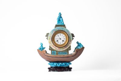 une horloge posée sur un support sur une surface blanche