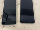two black samsung phones sitting side by side on a table