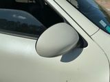 a white car with a side mirror on the side of the road