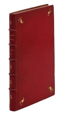 un livre rouge avec des bordures dorées et une couverture plaquée or