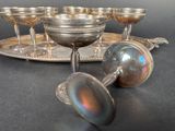 a silver tray with silver cups on it and a silver tray with silver cups on it