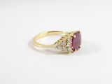 a close up of a gold ring with a ruby stone and diamonds