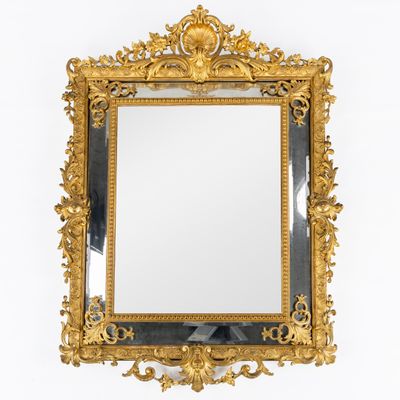 un miroir encadré d'or sur un mur blanc avec un fond blanc