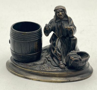 a figurine of a woman sitting next to a barrel