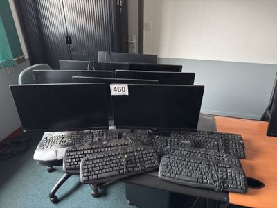 plusieurs écrans d'ordinateur et claviers posés sur un bureau dans un bureau