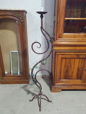 a tall metal candle holder with a decorative design on it