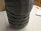 un vase noir posé sur une table blanche