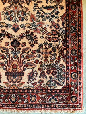 tapis persan ancien avec un motif floral sur fond bleu